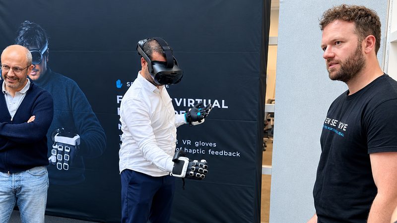 SenseGlove’un Rotterdam’daki merkezinde haptik eldiven ve VR başlığıyla bir simülasyonu deneyen katılımcı.